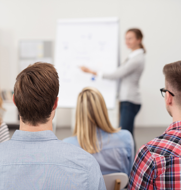 Personen schauen auf ein Whiteboard während einer Schulung